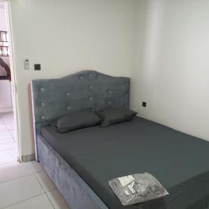 a bed in a room with a blue couch at Apache appartement in Paramaribo