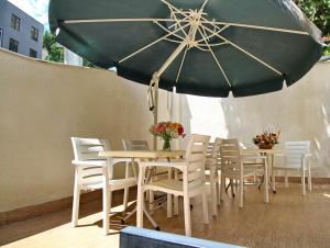 第比利斯villa old sololaki的一张桌子和椅子,配有绿色雨伞