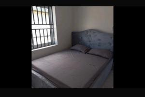 a bed with a blue headboard in a bedroom at Apache appartement in Paramaribo