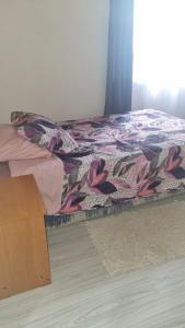 a bed with a colorful quilt on top of it at La mama Pocho in Chile Chico