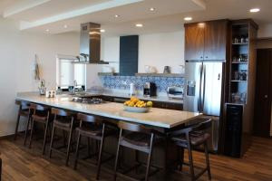 a kitchen with a large island with bar stools at Vista Delfin Beach House in San Carlos