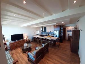a large living room with a table and a kitchen at Vista Delfin Beach House in San Carlos