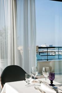 a table with three wine glasses and a window at JR Hotels Bari Grande Albergo delle Nazioni in Bari