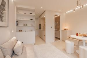 a white living room with a table and a couch at Zilte Rust - luxe studio met private parking in Knokke-Heist
