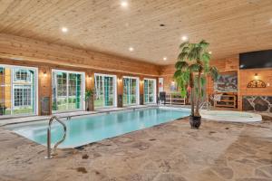une piscine dans une pièce avec un plafond en bois dans l'établissement Domaine Rivière Sacacomie - Chalet l'Hirondelle, à Saint-Alexis-des-Monts