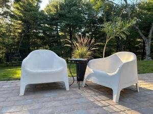 two white chairs sitting on top of a patio at An Locha B&B in Bear Tavern