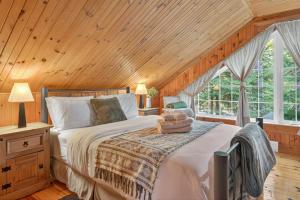une chambre avec un lit et un plafond en bois dans l'établissement Domaine Rivière Sacacomie - Chalet l'Hirondelle, à Saint-Alexis-des-Monts 17 autres photos
