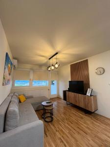 a living room with a couch and a flat screen tv at Stan na dan Kalin in Bugojno