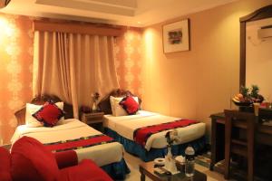 a hotel room with two beds and a couch at Sea Shell Hotel - Sales & Booking Office in Bāiljuri