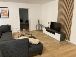 a living room with a couch and a flat screen tv at Ferienwohnung Dorfliebe Minden by Engelmann in Minden
