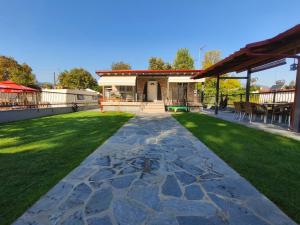 a backyard with a stone walkway and grass at Villa Sofia By The Sea in Leptokarya