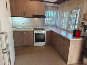 a kitchen with wooden cabinets and a white stove top oven at Villa Sofia By The Sea in Leptokarya