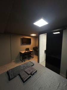 een slaapkamer met een bed, een bureau en een televisie bij Kit aconchegante na W3 Norte in Brasilia