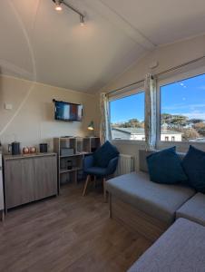 a living room with a couch and a window at Modern Style Pet Friendly Holiday Home sited on Durdle Door Holiday Park in West Lulworth