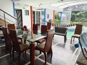 a dining room with a table and chairs and a pool at Villa campestre en conjunto residencial in Arbeláez