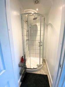 a shower with a glass door in a bathroom at Thornton Road Lodge -Room 2 in Bradford