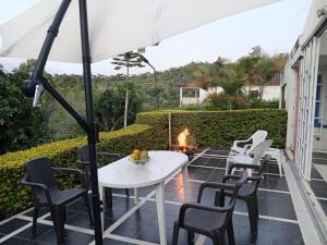a patio with a table and chairs and a fire pit at Villa campestre en conjunto residencial in Arbeláez