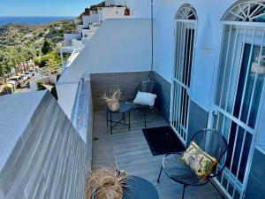 モハカルにあるSunrise Suiteの建物の上に椅子とテーブルが置かれたバルコニー