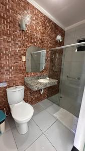 a bathroom with a toilet and a sink and a shower at Pousada Marihá in Piranhas