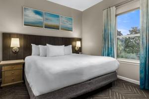 Un dormitorio con una cama grande y una ventana en Club Wyndham Beach Street Cottages, en Destin