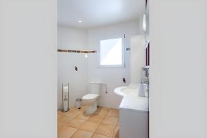 une salle de bain blanche avec toilettes et lavabo dans l'établissement Chez Brigitte et Sylvain, à Annecy 6 autres photos