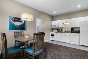 a kitchen and dining room with a table and chairs at Club Wyndham Beach Street Cottages in Destin