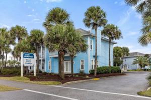 a blue house with palm trees in front of it at Club Wyndham Beach Street Cottages in Destin