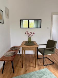 a room with a table and a chair and a vase of flowers at Grüne Oase in Stadtnähe in Unna