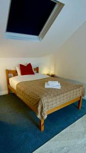 a bedroom with a bed with a red pillow at Durham City Centre Hideaway - Terrace with View & Parking in Durham