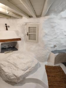 ein mit weißem Marmor verkleideter Raum mit einem Fenster in der Unterkunft Artemis cottage in Super Paradise Beach