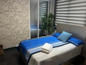 a bed with blue and white blankets and pillows at Dreamvillage in Boca Chica