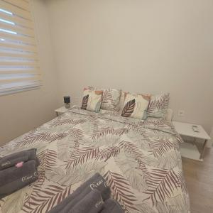 ein Schlafzimmer mit einem Bett mit einer schwarz-weißen Bettdecke in der Unterkunft Luxury Suite Old Plovdiv with parking in Plowdiw