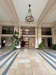 an empty lobby with a chandelier in a building at Évasion tout confort au T3 bis Pyrénées Palace in La Celle-sous-Gouzon