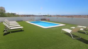 コティージョにあるLa Concha sunsetのパティオ(スイミングプール、芝生の椅子2脚付)