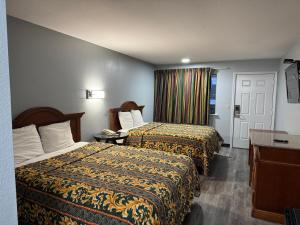 a hotel room with two beds and a window at Claremore Motor Inn in Claremore
