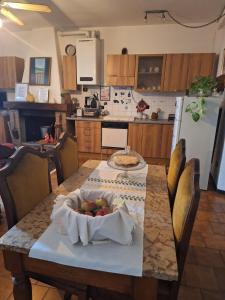 a kitchen with a table with a bowl of fruit on it at Mini appartamento con formula B&B in Montasico +4 photos