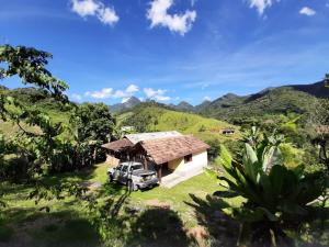 a truck parked in front of a small house at Refúgio da Colina Lumiar in Nova Friburgo