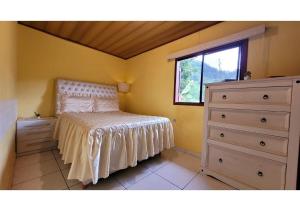 a bedroom with a bed and a dresser and a window at Refúgio da Colina Lumiar in Nova Friburgo +44 photos