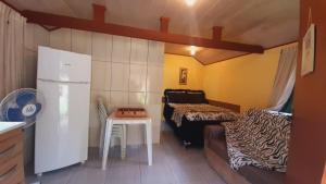 a small room with a refrigerator and a table at Refúgio da Colina Lumiar in Nova Friburgo