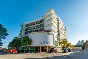 a large white building with cars parked in front of it at Acamar Beach Resort in Acapulco