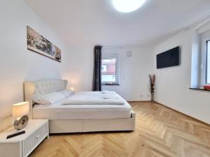 a white bedroom with a bed and a window at Ravensburg City Apartment in Ravensburg