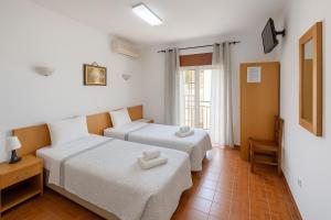 ein Hotelzimmer mit zwei Betten und einem Fenster in der Unterkunft Lagos Central Suite DBV Guesthouse in Lagos