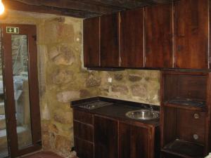 a kitchen with wooden cabinets and a sink at Casa do Castelo de Celorico in Celorico da Beira