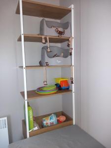 ein Zimmer mit einem Regal mit Spielzeug darauf in der Unterkunft Camping le soleil d'or Mobil Home in Montalivet-les-Bains