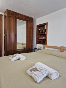 2 toallas sentadas encima de una cama con espejo en Casa Camilla, Casa Vacanze sulle colline di Lerma, en Lerma