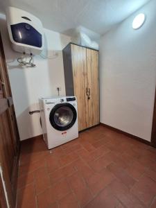 - Lavadora y secadora en una habitación con puerta en Casa Camilla, Casa Vacanze sulle colline di Lerma, en Lerma