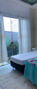 a bedroom with a bed and a large window at hospedaCOP30Roma in Belém