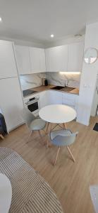 a small kitchen with a table and two chairs at Le Jasmin - charmant T2 en hypercentre d'Agen in Agen