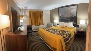 ein kleines Hotelzimmer mit einem Bett und einem Schreibtisch in der Unterkunft Mid Rest Inn in Lexington