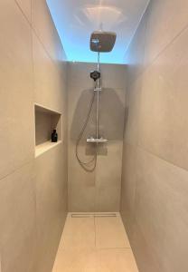 a bathroom with a shower with a light on the ceiling at Premium Landhauswohnung in Neuenkirchen